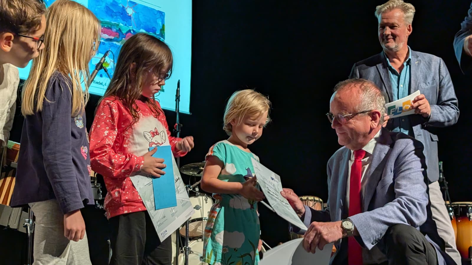 Minister Tabbert übergibt Urkunden an Kinder, die am Malwettbewerb teilgenommen haben.